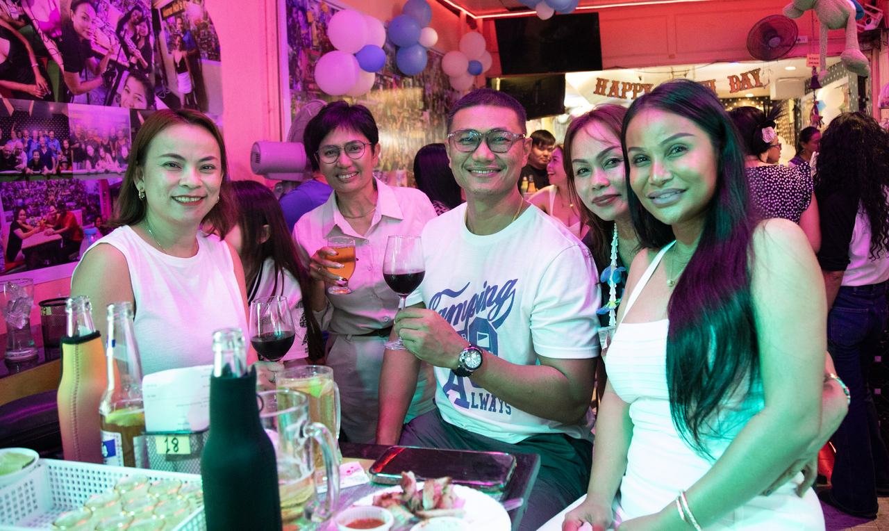 Raising a toast together under the birthday banner