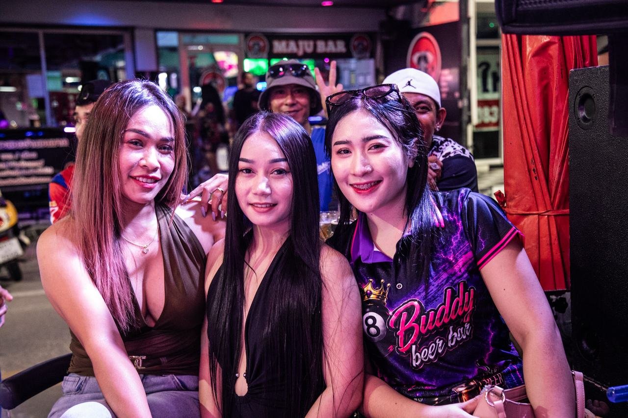 Friends posing together on the lively street outside the bar