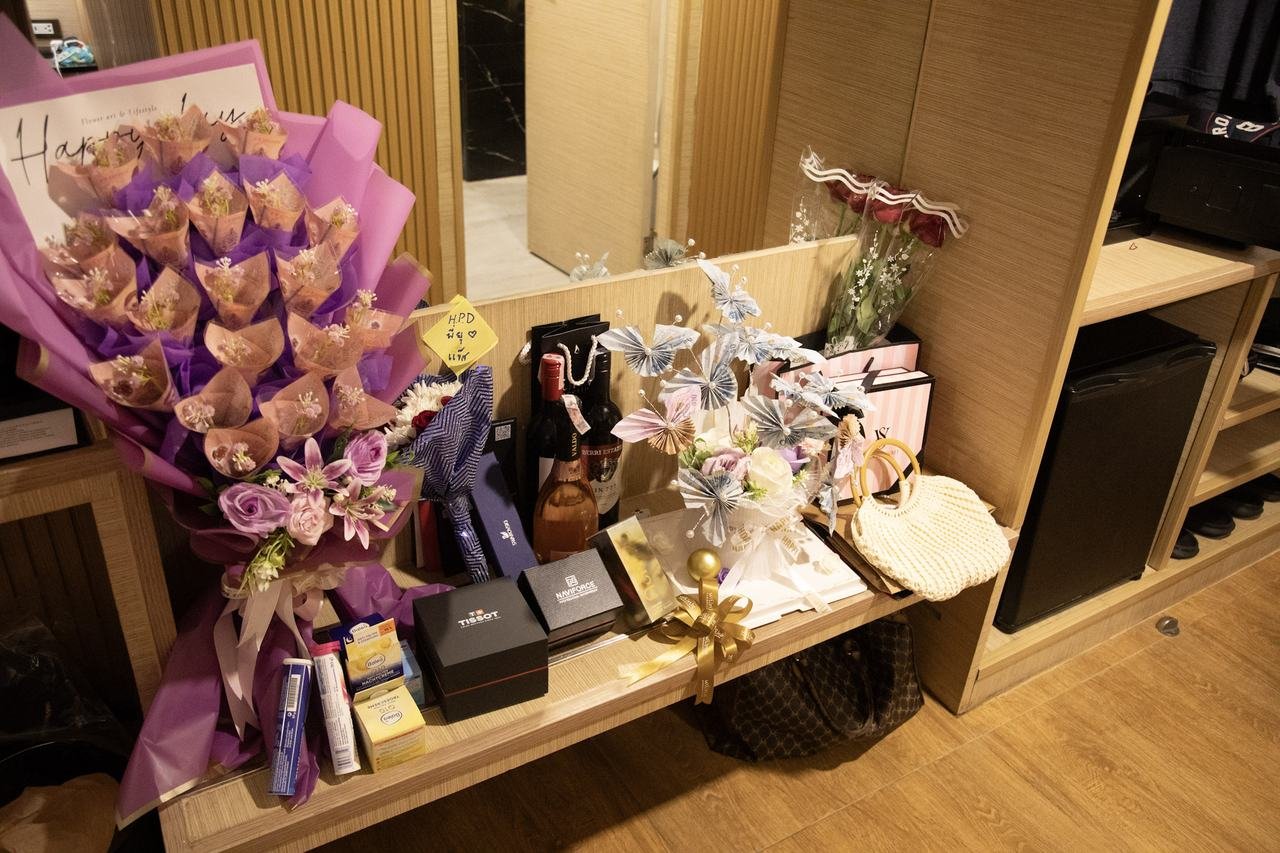 Flowers, watch, and gifts laid out for the birthday